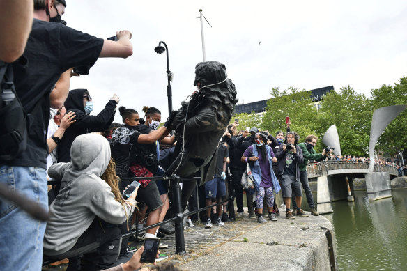 Protesters throw a statue of slave trader Edward Colston into the Bristol harbour this week.