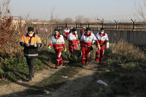 Rescue workers carry the body of a victim of the Ukraine International Airlines flight that was shot down.