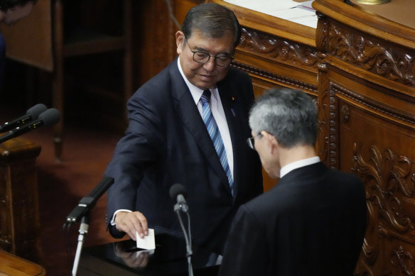 Japanese Prime Minister Shigeru Ishiba, left, votes for a run-off for a new prime minister on Monday. 