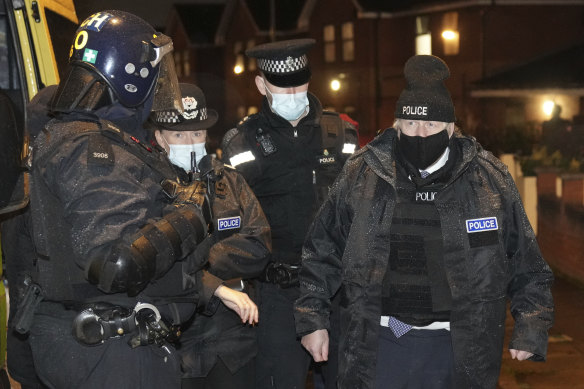 Britain’s Prime Minister Boris Johnson, right, observes an early morning police raid on a home in Liverpool, England, ahead of the publication of the government’s 10-year drug strategy. 