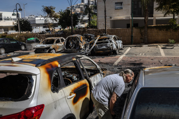 Mikhail Shvetz surveys the damage to cars gutted by fires set when a rocket from Gaza struck the parking lot of an apartment complex in Ashkelon, Israel.