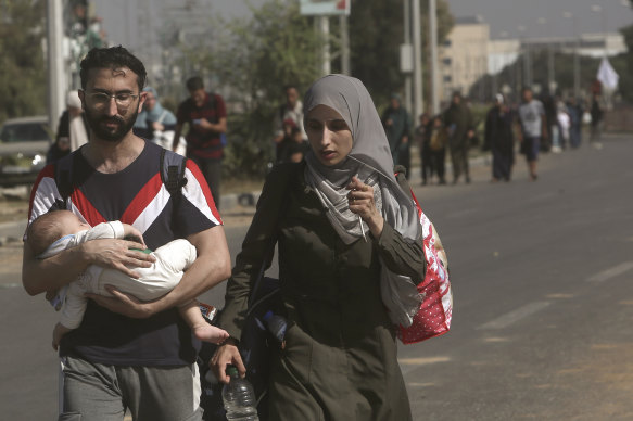 Palestinians flee Gaza City to the southern Gaza Strip on Salah al-Din street in Bureij on Tuesday.