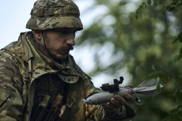 A Ukrainian soldier loads a bomb on a drone near Bakhmut, the site of fierce battles with Russian forces in the Donetsk region on Sunday.