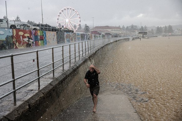 A swimmer heads for cover as hail hits Bondi during a severe storm.
