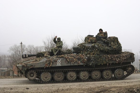 Russian soldiers ride atop of self-propelled gun at an area in the Kursk region of Russia.