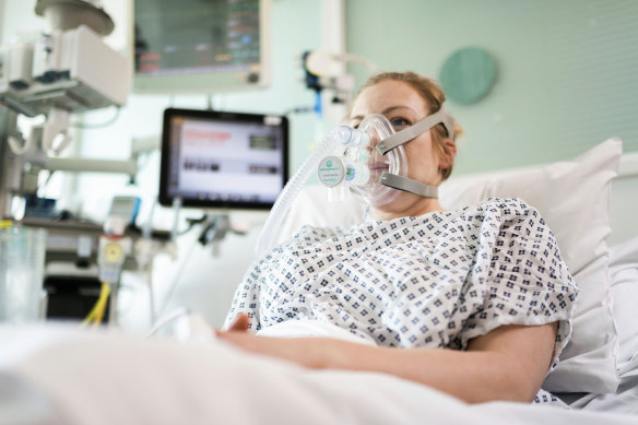 A volunteer demonstrates the use of a CPAP device at University College London Hospital.