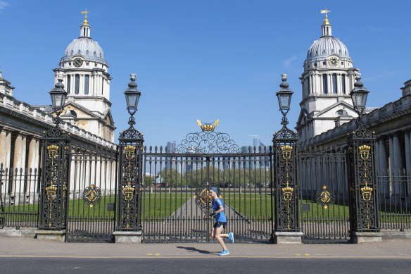 A runner passes the Old Royal Naval College, in Greenwich, on the course of the London Marathon, which has been postponed. 