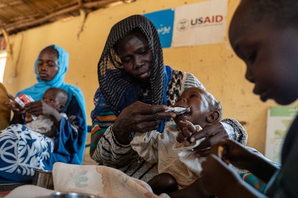A Sudanese mother feeds her  severely malnourished son with peanut paste.