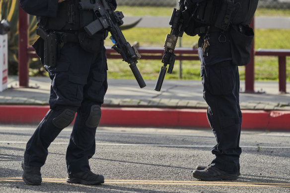 Police officers stand near the Star Dance Studio where a gunman killed 10 people and injured another 10 in Monterey Park