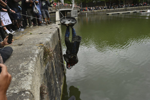 A statue of slave trader Edward Colston meets a watery end in the English port city of Bristol on Sunday.