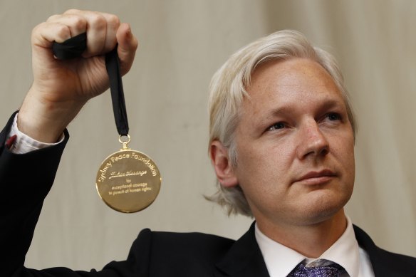 WikiLeaks founder Julian Assange holds up his Sydney Peace Prize after receiving the award in 2011.
