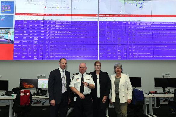 Rural Fire Service chief Shane Fitzsimmons with Britain's Foreign Secretary Dominic Raab, left, and Australian Foreign Minister Marise Payne in front of giant screens at RFS headquarters in Sydney Olympic Park during the summer bushfires.