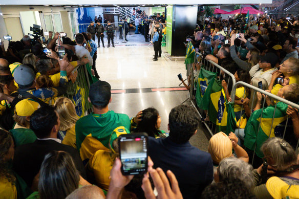 Supporters of former president Jair Bolsonaro wait for his arrival at the airport in Brasilia.