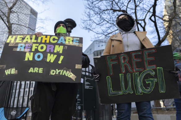 Luigi Mangione supporters hold signs outside the Supreme Court in New York.