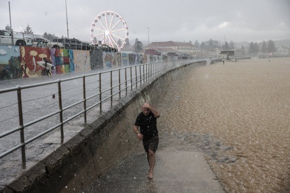 A beachgoer runs from the hail at Bondi Beach. 