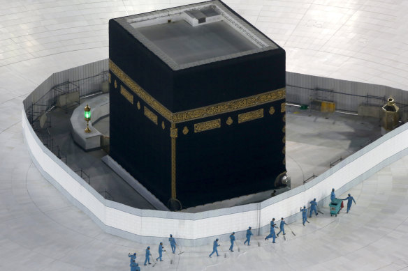Workers disinfect the ground around the Kaaba, the cubic building at the Grand Mosque, in the Muslim holy city of Mecca, Saudi Arabia. The site is now closed.