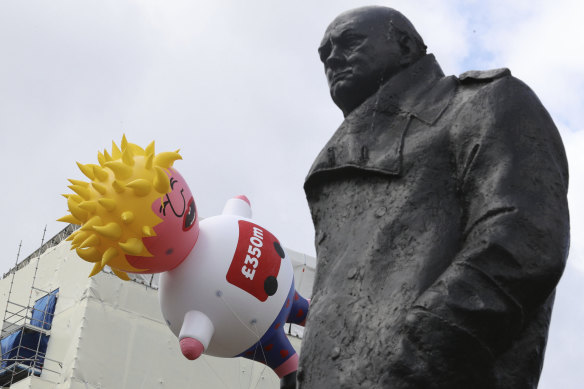 A blimp depicting Boris Johnson floats past a statue of Winston Churchill in London last month.