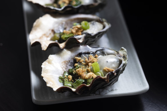 Grilled oysters with onion oil and crushed peanuts.