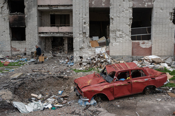 A man carries his belongings out of a heavily damaged apartment building in Chernihiv, north-east of Kyiv.