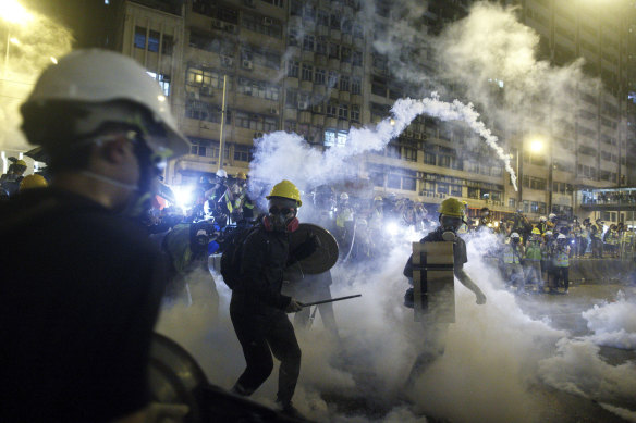 Protesters react to tear gas during a confrontation with riot police in Hong Kong on Sunday night.