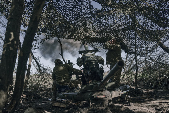 Ukrainian soldiers fire a cannon near Bakhmut.