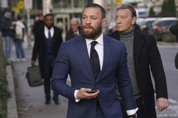 Mixed martial arts fighter Conor McGregor, front, and his father Tony, right, outside the High Court in Dublin, Ireland.