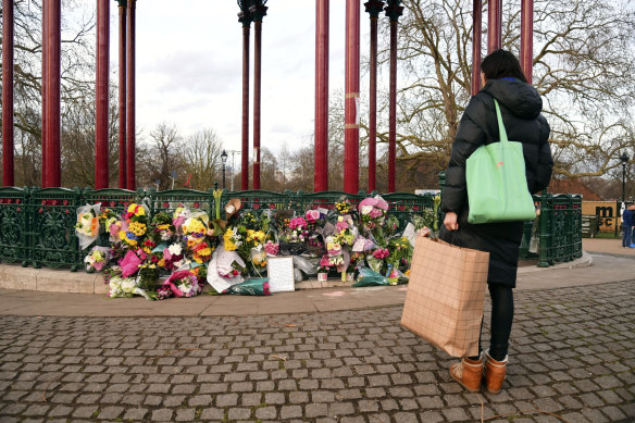 A woman stops to view flowers left at the bandstand on Clapham Common to mourn Sarah Everard. 