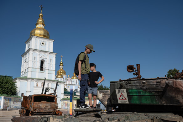 Boys inspect burnt Russian military vehicles that are displayed on St. Michaels Square on July 28 in Kyiv.