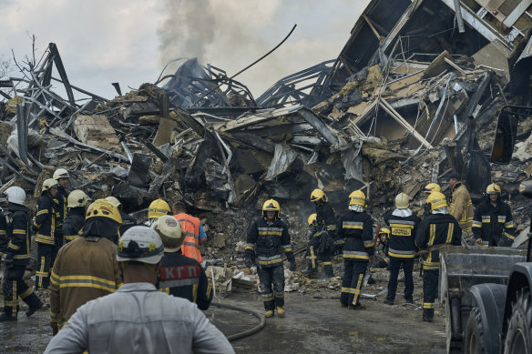 Emergency service personnel work at the site of a destroyed building after a Russian attack in Odesa.