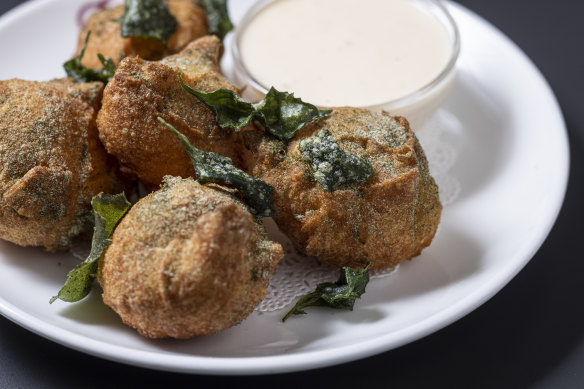 Potato doughnuts with creamy fondue and saltbush.