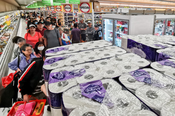 People wait their turn to purchase toilet paper.