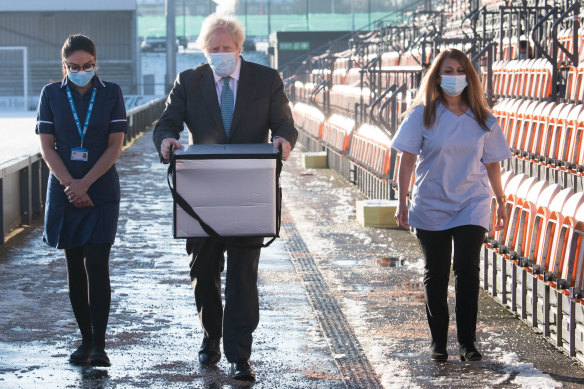 UK Prime Minister Boris Johnson carries doses of the COVID-19 vaccine. 