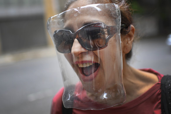 A woman wears a makeshift face shield made from a plastic bottle container as a precaution against the new coronavirus in Caracas.