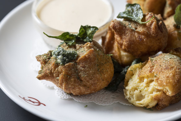 Potato doughnuts with creamy fondue and saltbush.