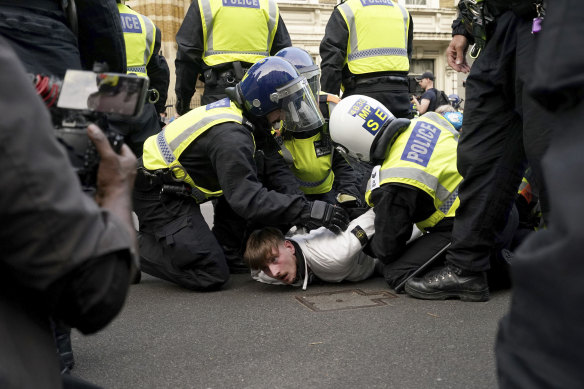 A protester is detained by police during the ‘Enough is Enough’ protest in Whitehall, London.