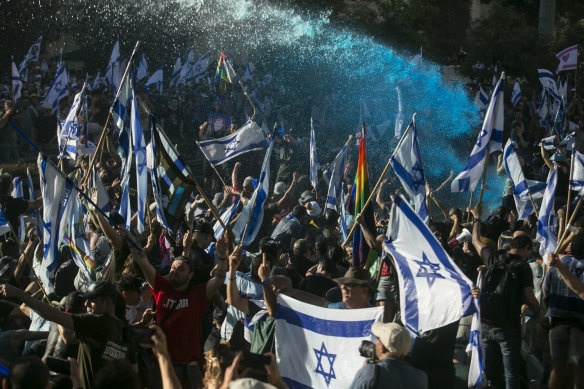 Police officers use water cannons to evacuate protesters from a main road in Jerusalem. 