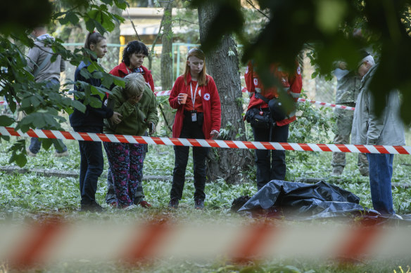 A woman (second from left) reacts to the dead bodies of her daughter and grandchild after a Russian strike in Kyiv, Ukraine, on Thursday.