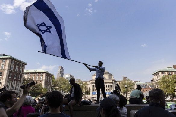 Columbia sophomore, David Lederer, waves a large Israeli flag outside the student protest encampment on the university’s campus in New York on Monday.