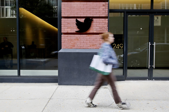 A woman walks past Twitter headquarters in New York City in October the day after Musk’s Twitter purchase. 