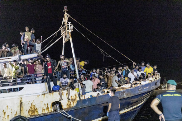 A fishing boat with migrants is docked at the port of the Sicilian island of Lampedusa, southern Italy, in September 2021. 