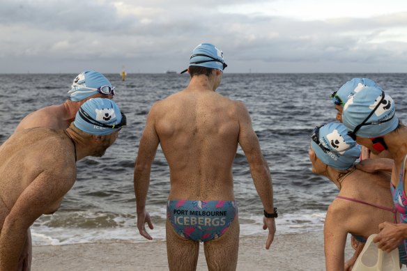 A brown substance sticks to the skin of swimmers in the bay.