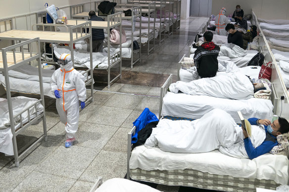 Patients diagnosed with the coronavirus settle at a temporary hospital set up in an exhibition centre in Wuhan on February 5, 2020.