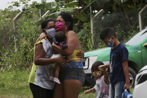 Relatives mourn at the roadside while awaiting the removal of the body of Arlen Bezerra, 39, a victim of COVID-19, in Manaus, Amazon state, Brazil.