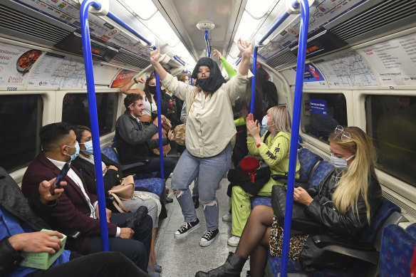 People ride a Northern Line train in London after the 10pm pub and restaurant curfew that has been prompted by the spread of COVID-19.
