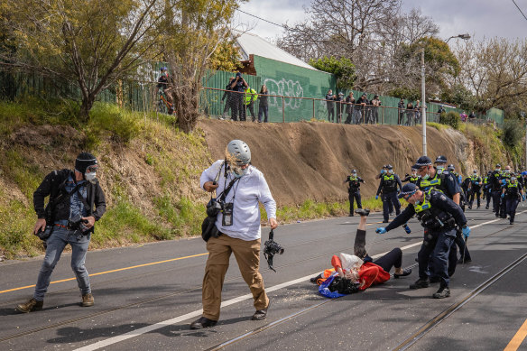 Age photographer Luis Ascui walks away after being pepper-sprayed by police during an anti-lockdown protest in Richmond.