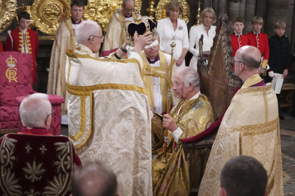 King Charles III receiving the St Edward's Crown at his coronation at Westminster Abbey.