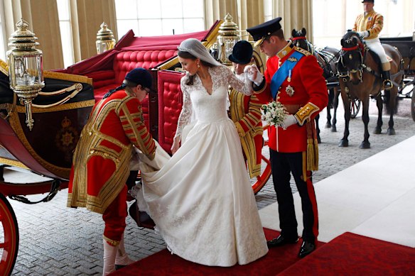 Prince William assists his bride Catherine from a coach at Buckingham Palace following their wedding.