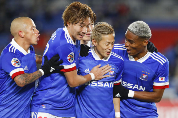 Yokohama F. Marinos' players celebrate a goal. 