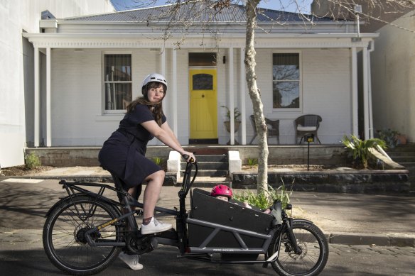Mali Lewis, pictured here with daughter Bea in North Melbourne, would like to cycle more but is frustrated by the lack of protected bike lanes.