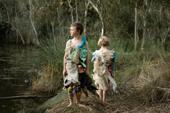 Photographer Daisy Noyes makes dresses out of rubbish she collects from Merri Creek. She and her sons Marlow, 6, and Augie, 8, model them by the creek for her photo series on climate anxiety.